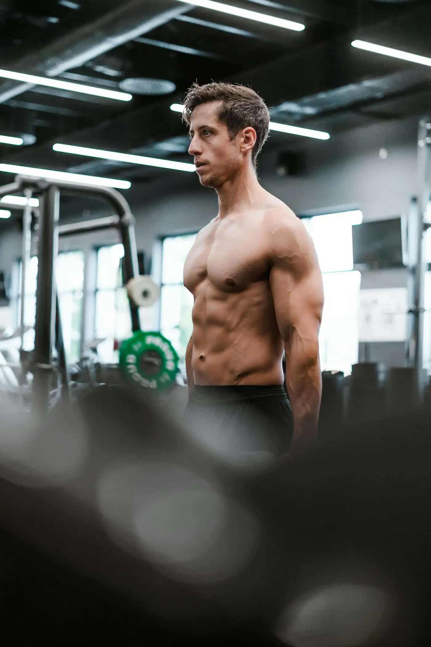 Mid-aged man training in a modern gym, lean and athletic — peptide research applied to longevity, recovery and continued strength