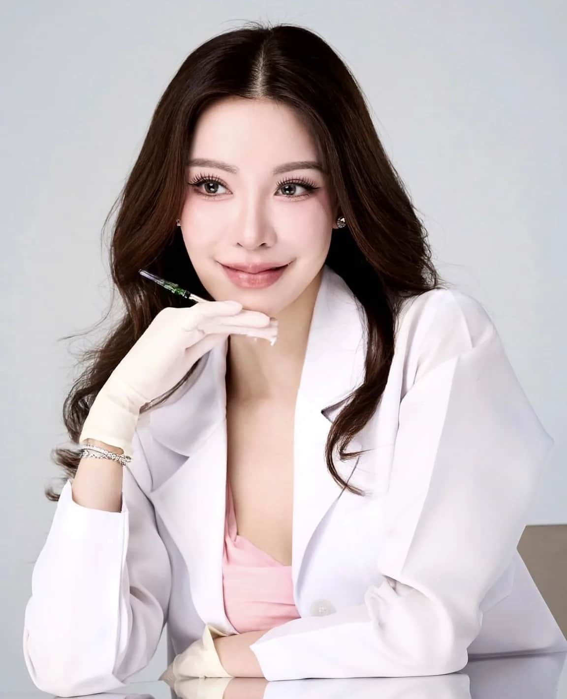 Dr. Pichaya Sangaunmu, beauty and longevity physician, holding an ampoule