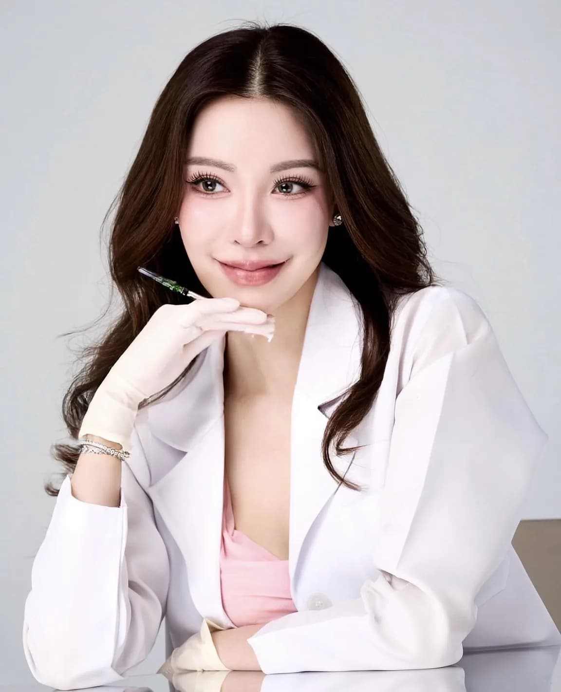 Dr. Pichaya Sangaunmu, beauty and longevity physician, holding an ampoule